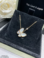 Gold butterfly pendant necklace with pale blue enamel petals on a chain