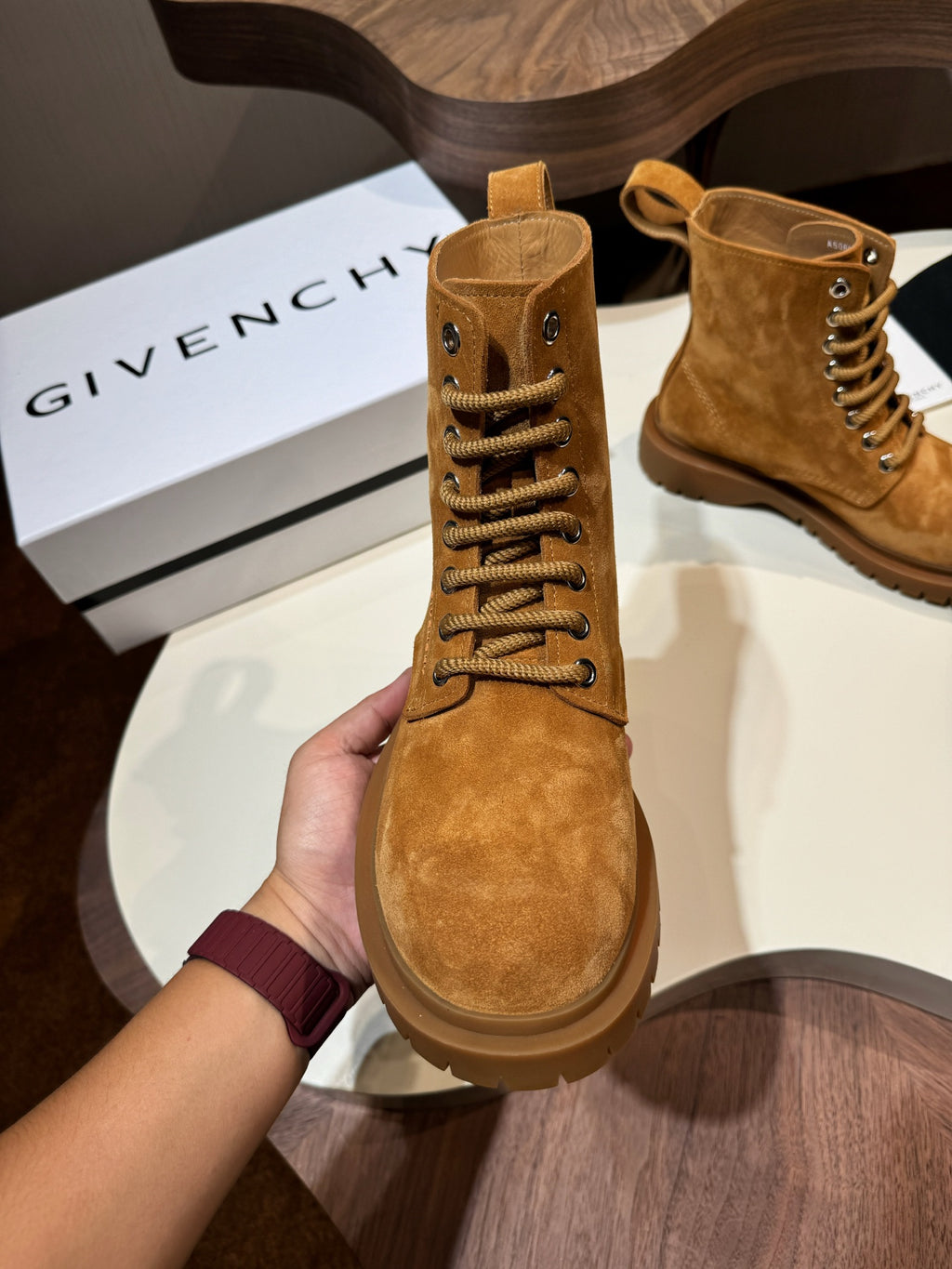 Tan suede lace-up boots with metal eyelets and pull tab