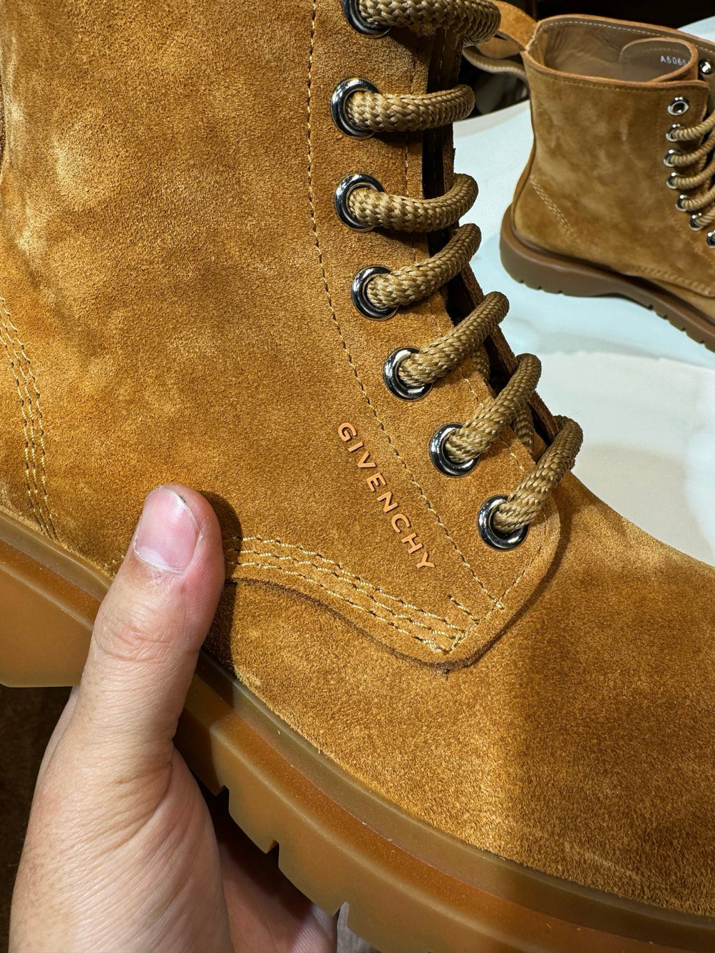 Tan suede lace-up boot close-up with GIVENCHY stitched text