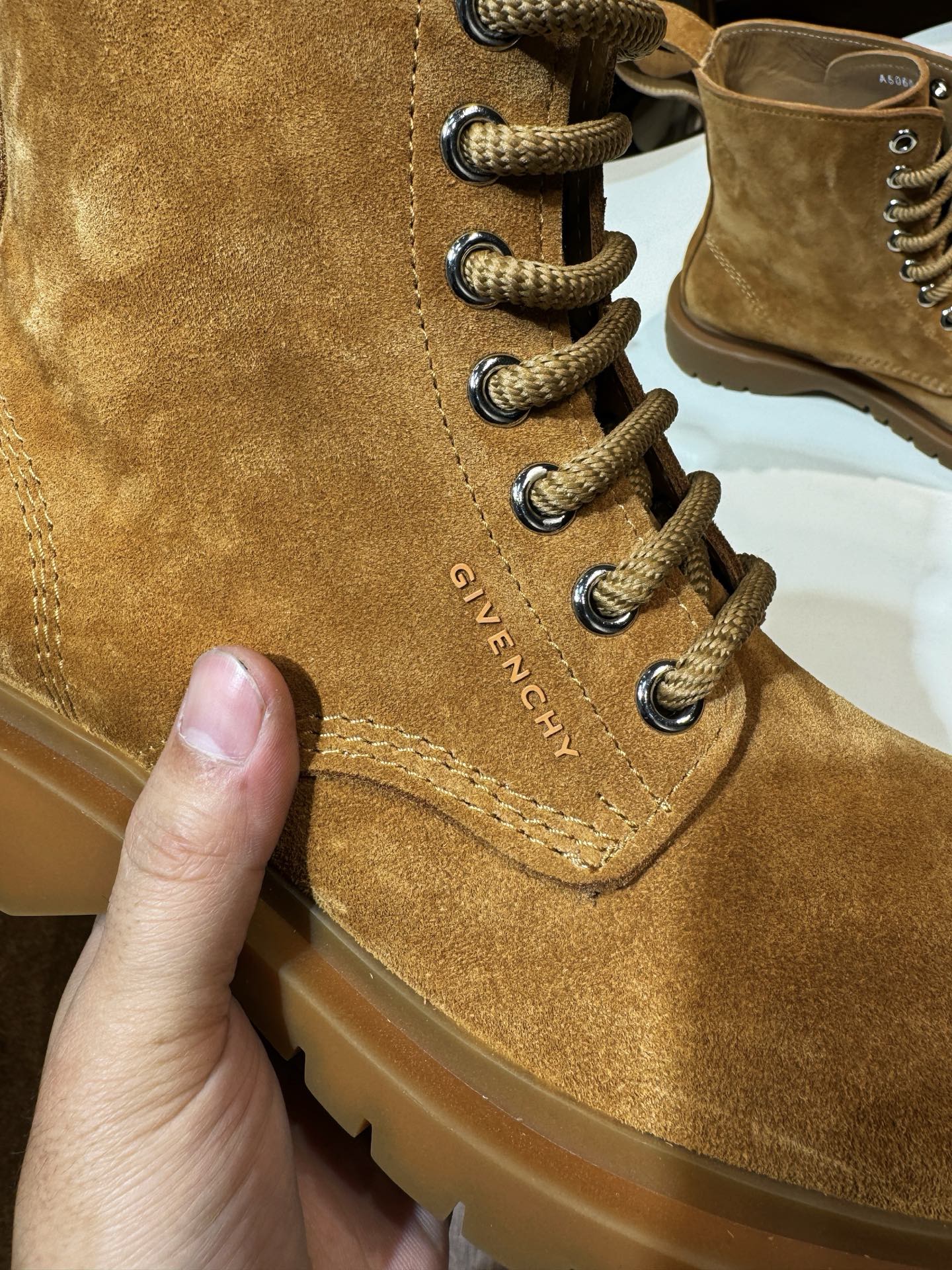 Tan suede lace-up boot close-up with GIVENCHY stitched text