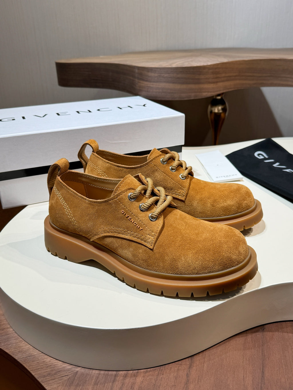 Tan suede lace-up shoes on display with brown lug sole