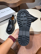 Black lace-up shoe with treaded outsole visible, heel and sole detail