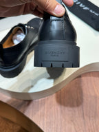 Black leather lace-up shoe heel close-up, embossed Givenchy logo on sole