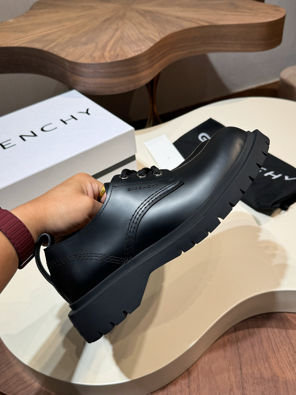 Black leather lace-up shoes with stitched toe and thick tread sole, close