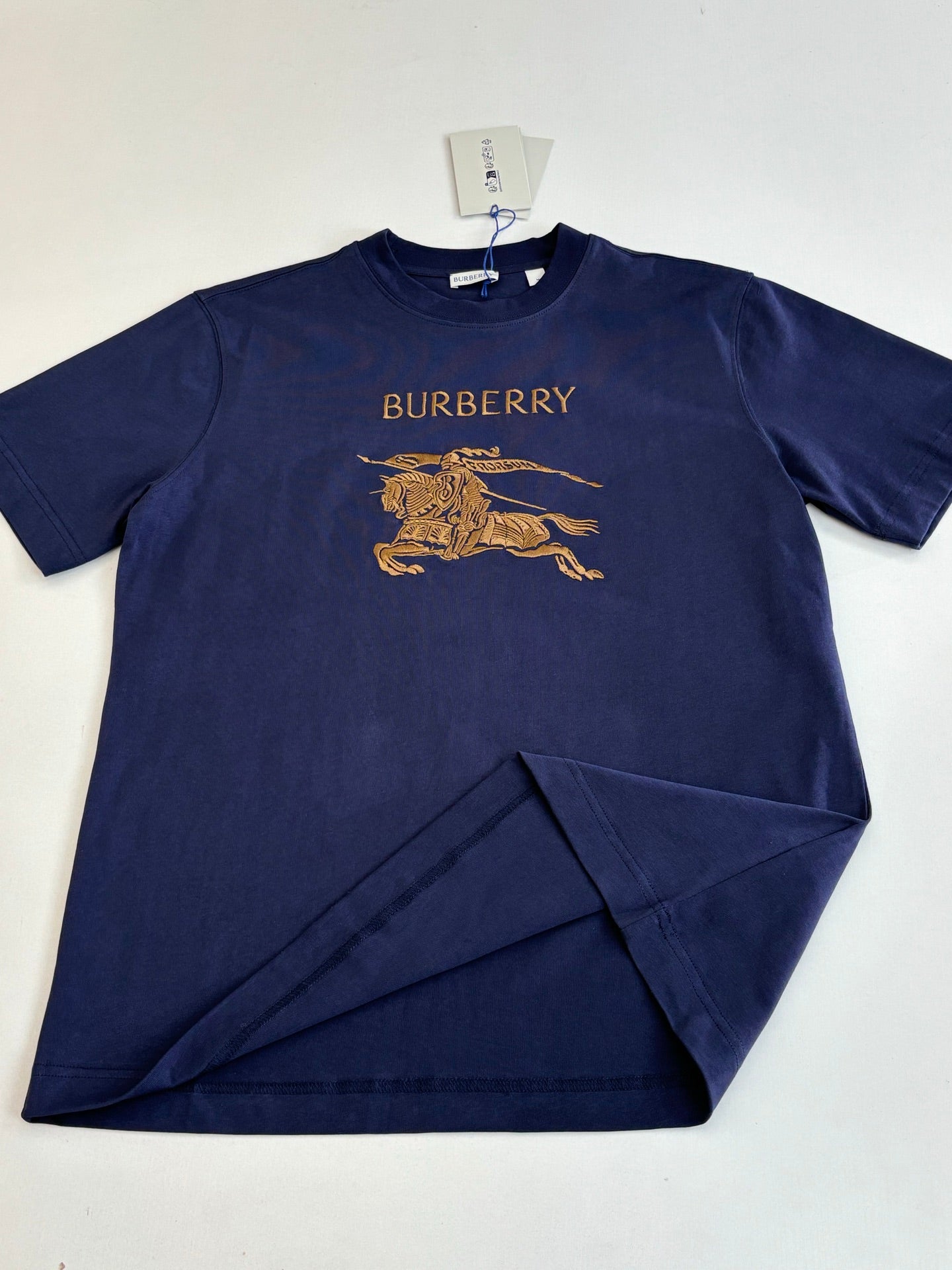 Dark blue short-sleeve T-shirt with Burberry text and gold horse graphic