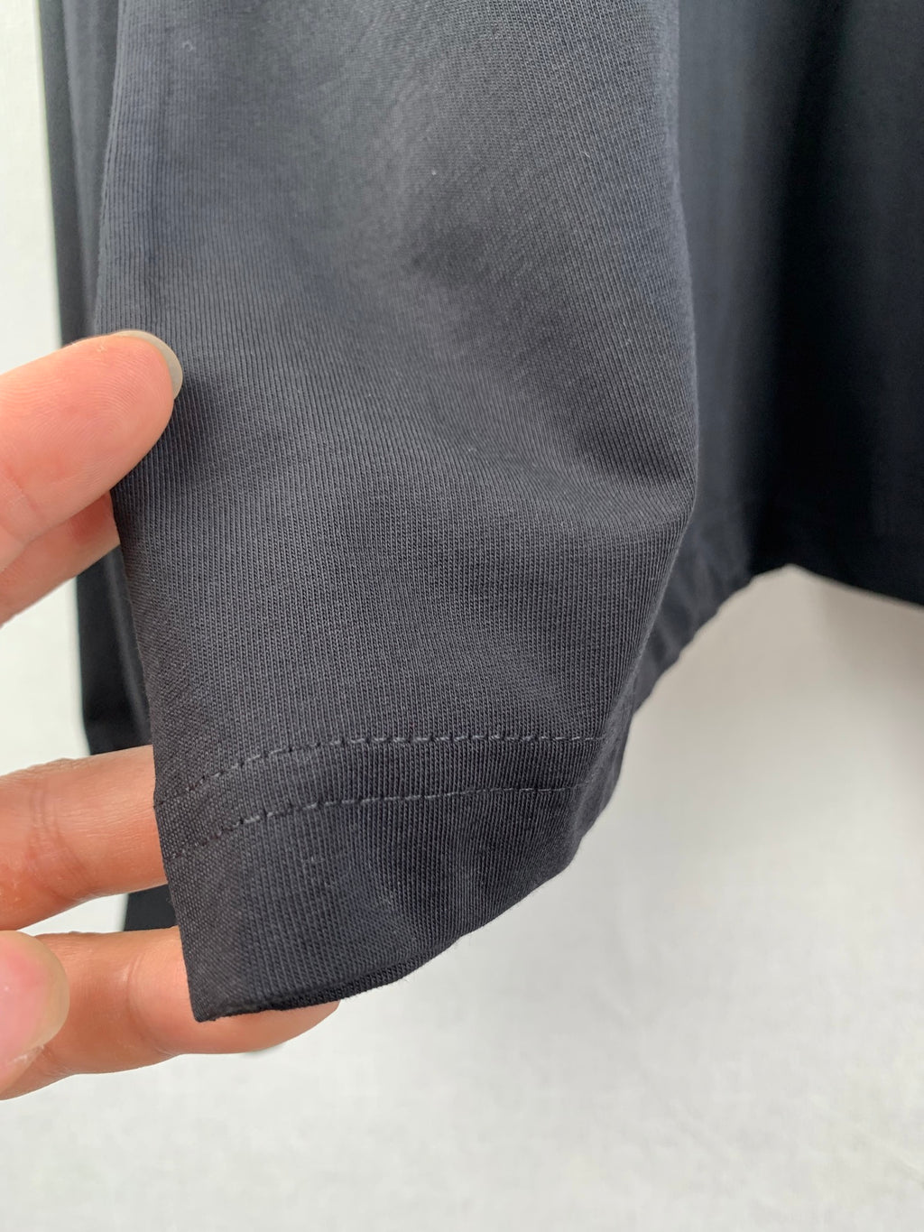 Stitched sleeve cuff hem on dark knit sweatshirt