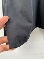 Stitched sleeve cuff hem on dark knit sweatshirt