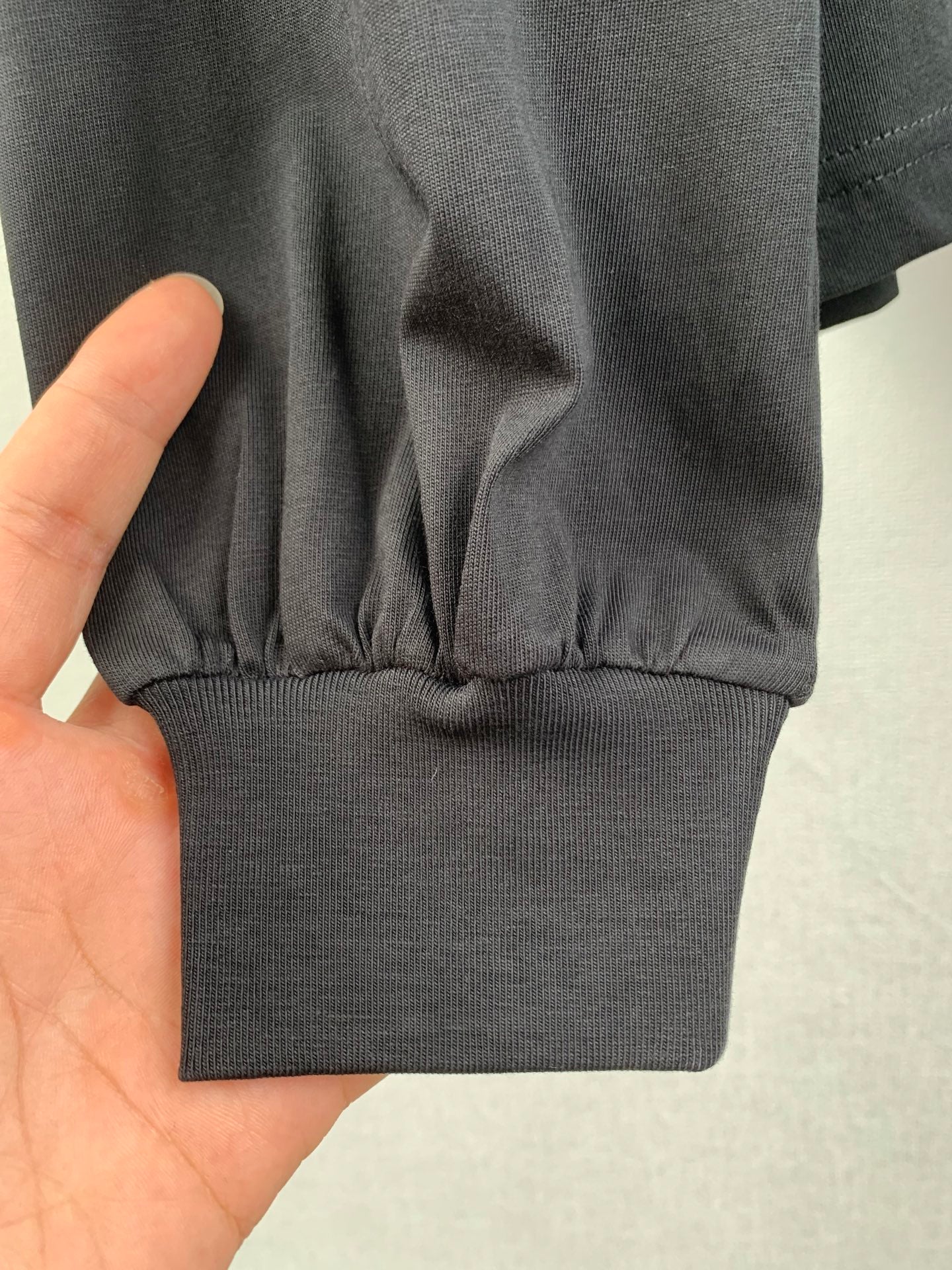 Ribbed sweatshirt hem and cuffs on dark knit fabric