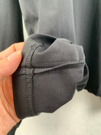 Seamed sleeve cuff corner on dark knit sweatshirt