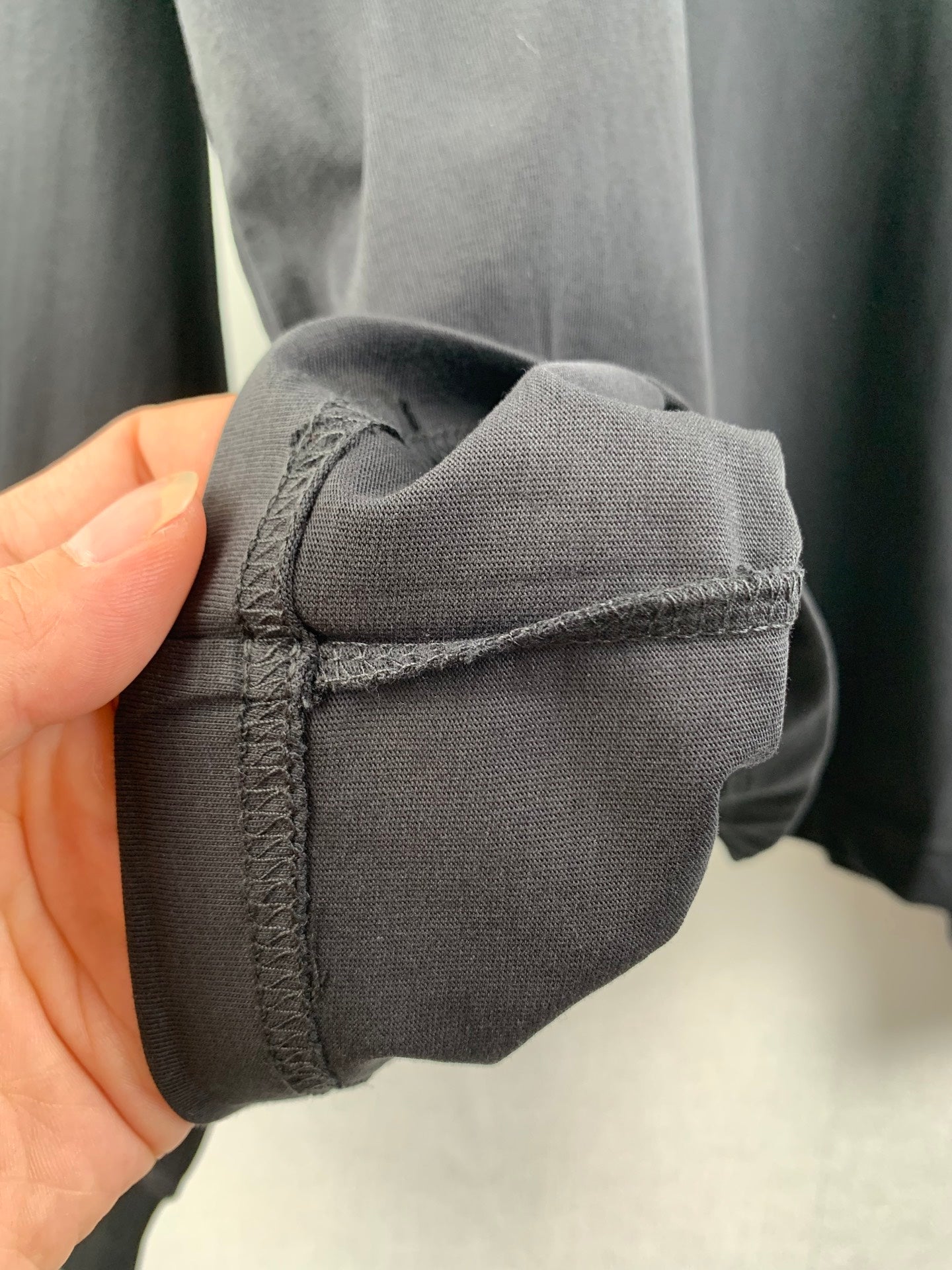 Seamed sleeve cuff corner on dark knit sweatshirt