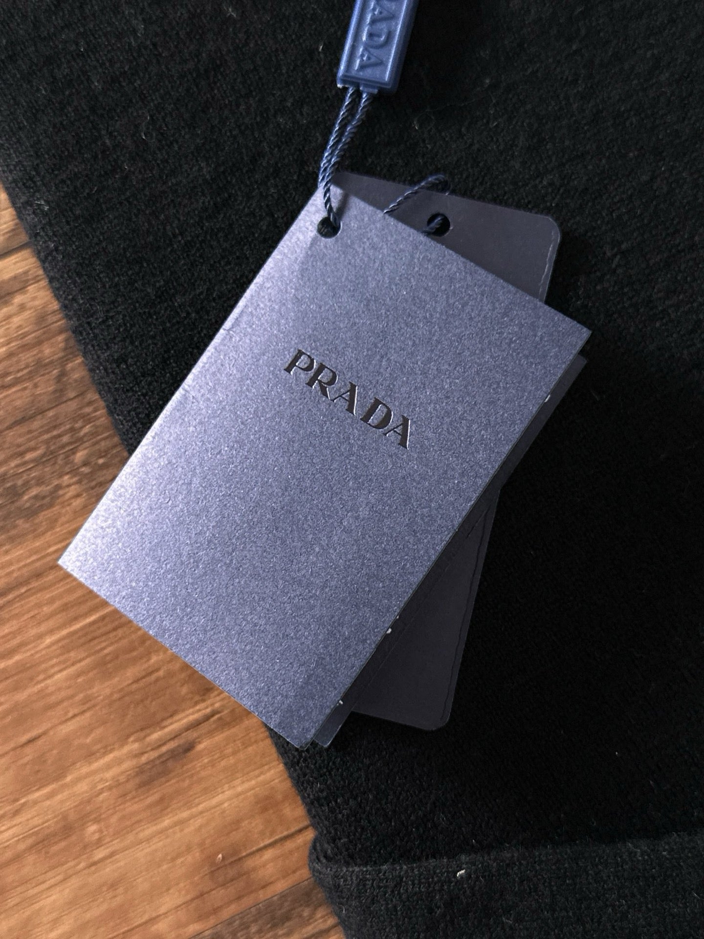 Black sweater with hanging PRADA logo price tag