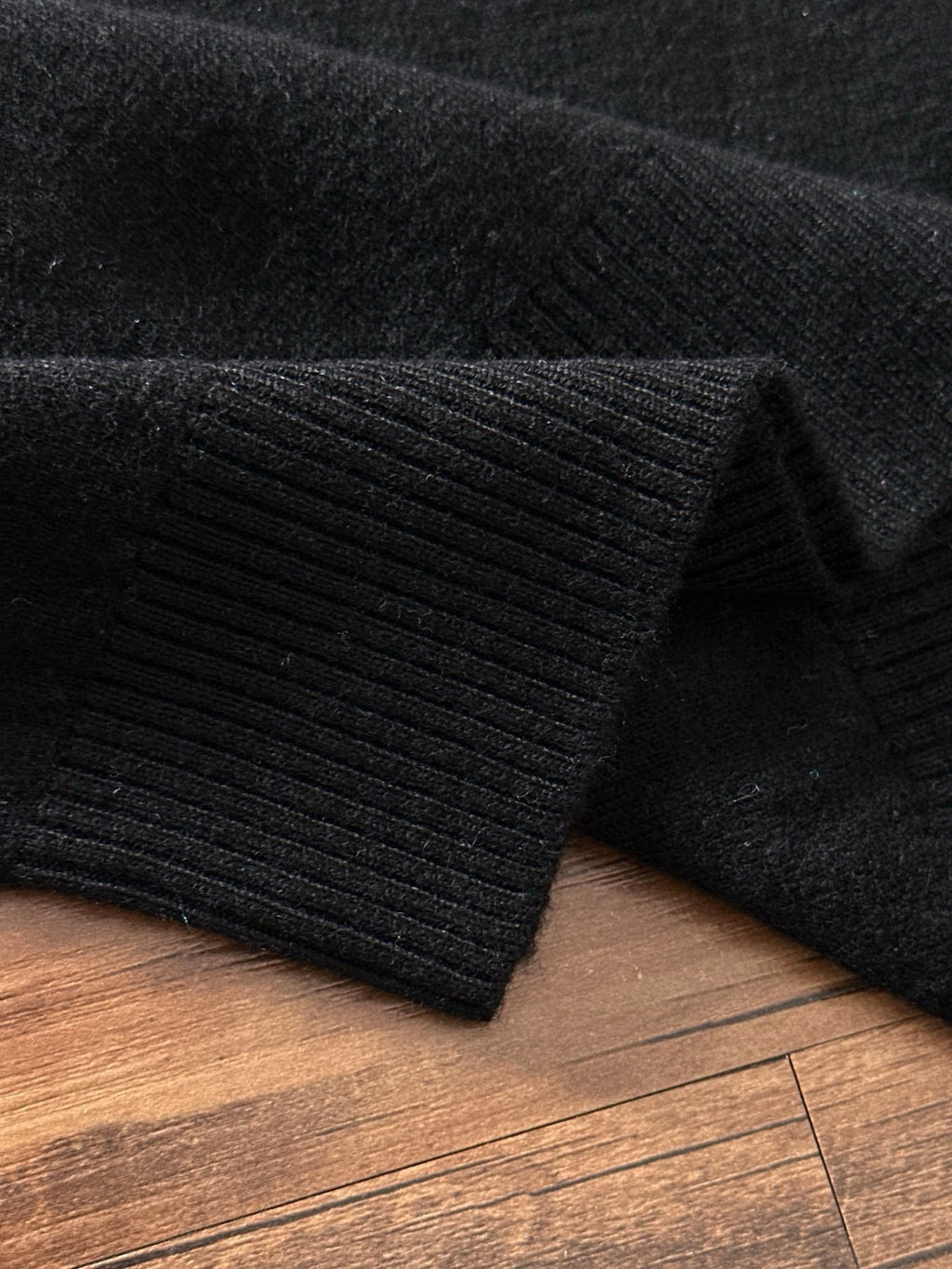 Black ribbed knit sweater cuff and hem detail
