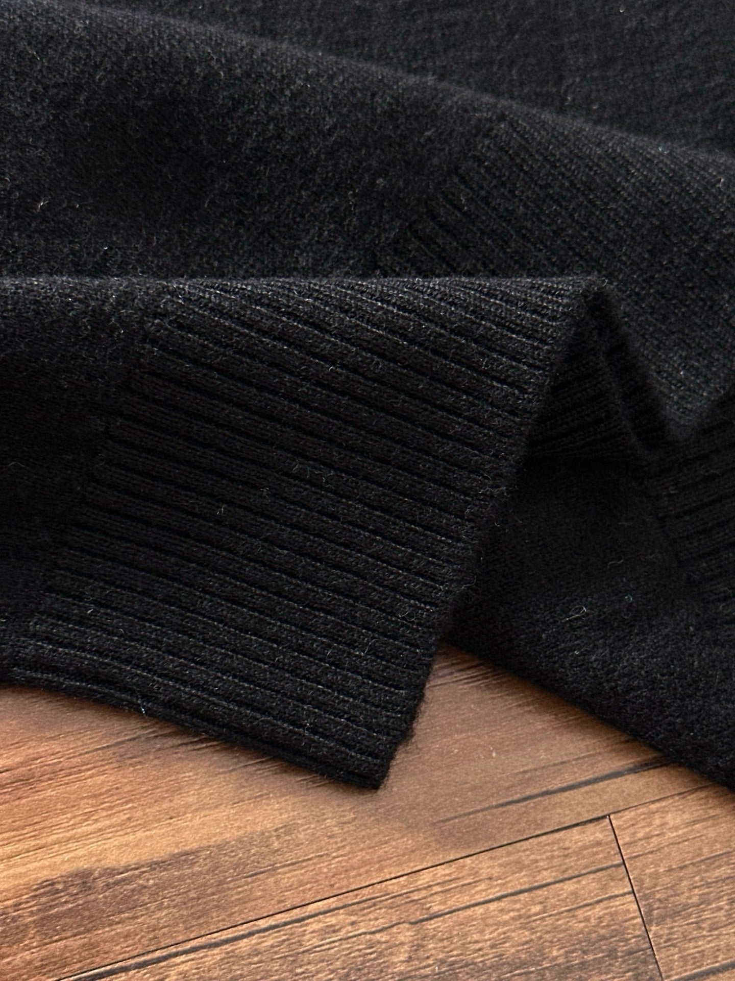 Black ribbed knit sweater cuff and hem detail