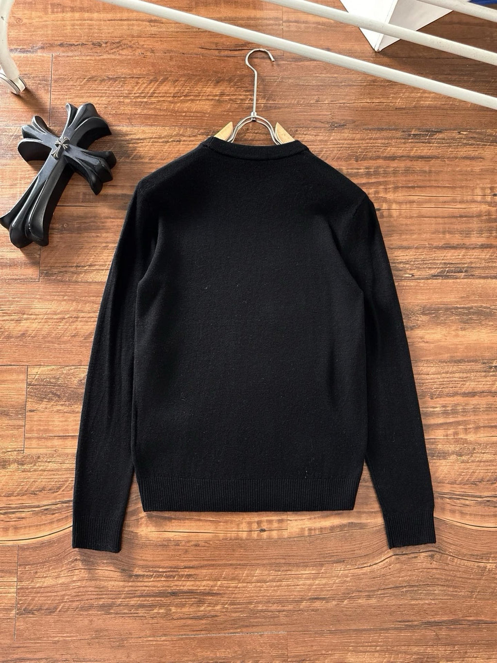 Black crewneck sweater back view on hanger with long sleeves