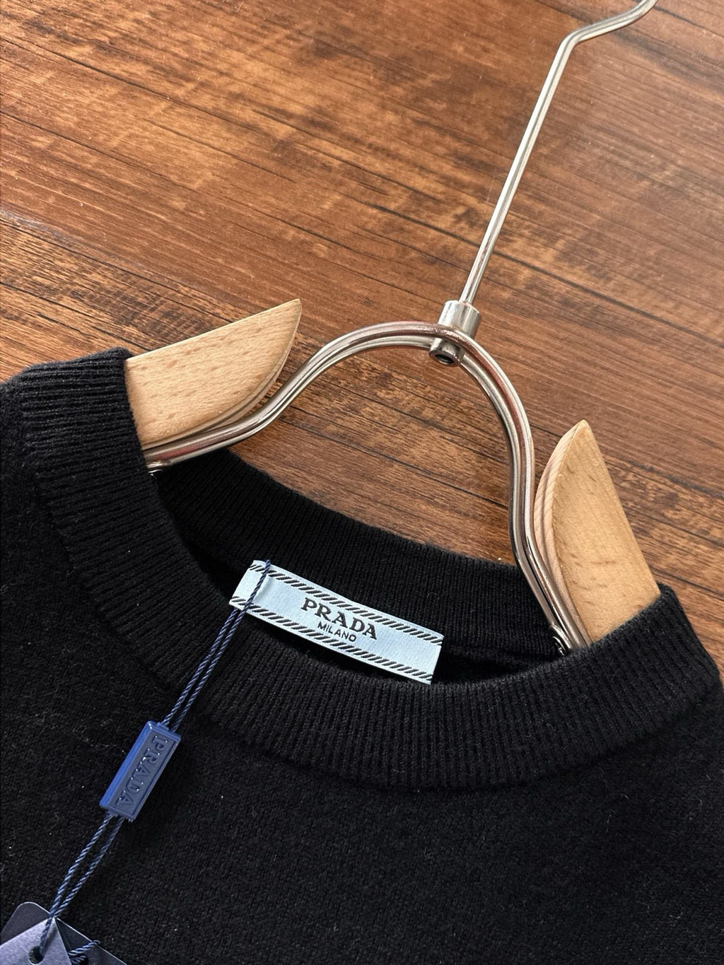 Black sweater neckline with inner brand label and hanging size tag