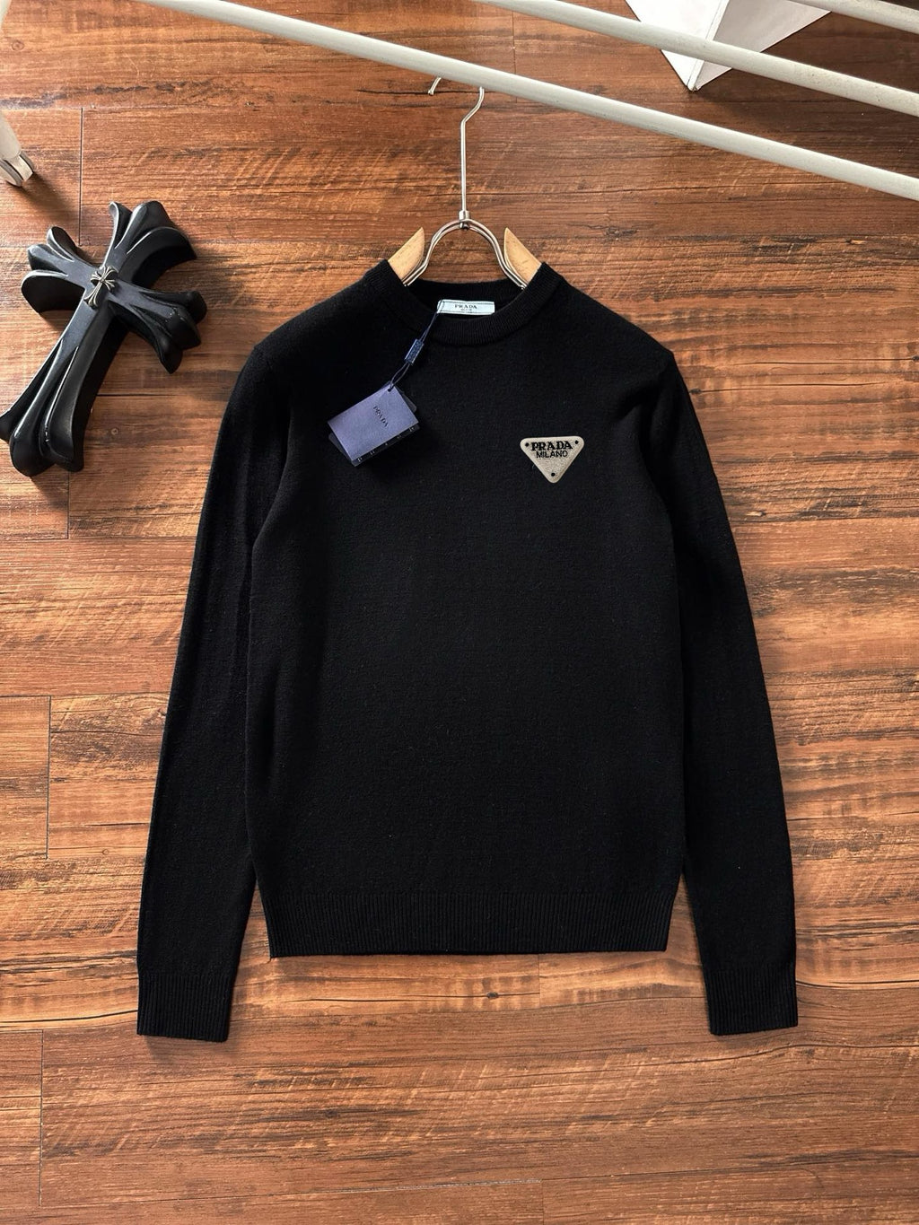 Black crewneck sweater with long sleeves and small triangular Prada Milano logo patch
