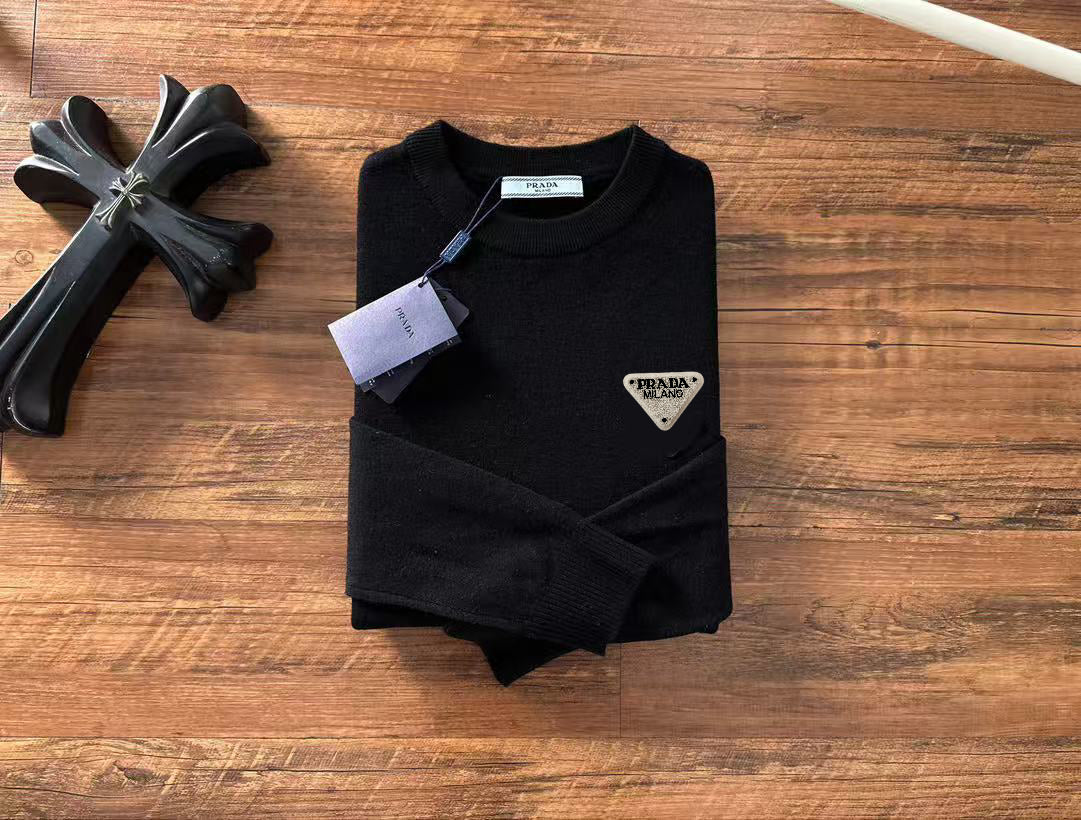 Folded black crewneck sweater with long sleeves and triangular Prada Milano logo patch