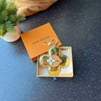Louis Vuitton gold flower keychain charm with tan center on orange box and white insert