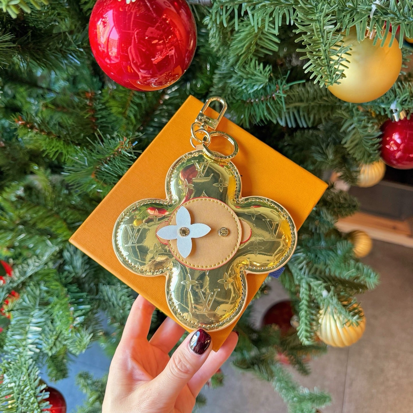 Louis Vuitton small bag keychain charm, gold floral shape with beige center and metal ring