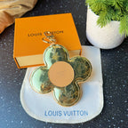 Louis Vuitton small bag charm keychain, gold flower shape with beige circular detail and ring