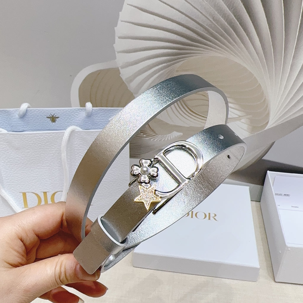 Silver metallic belt with star-and-flower charm and oval buckle, held in hand