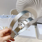 Silver metallic belt with star-and-flower charm and oval buckle, held in hand
