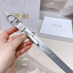 Silver metallic belt with engraved text on strap and oval buckle