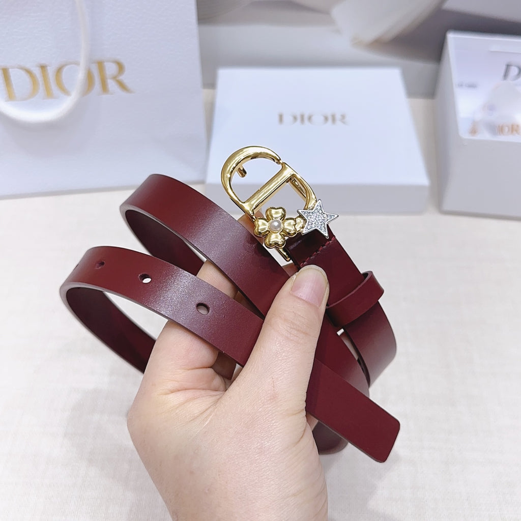 Dior belt close-up: burgundy strap with gold buckle, star charm, and pearl flowers