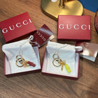 Gucci keychain pair with gold rings and red/green tassels in gift boxes