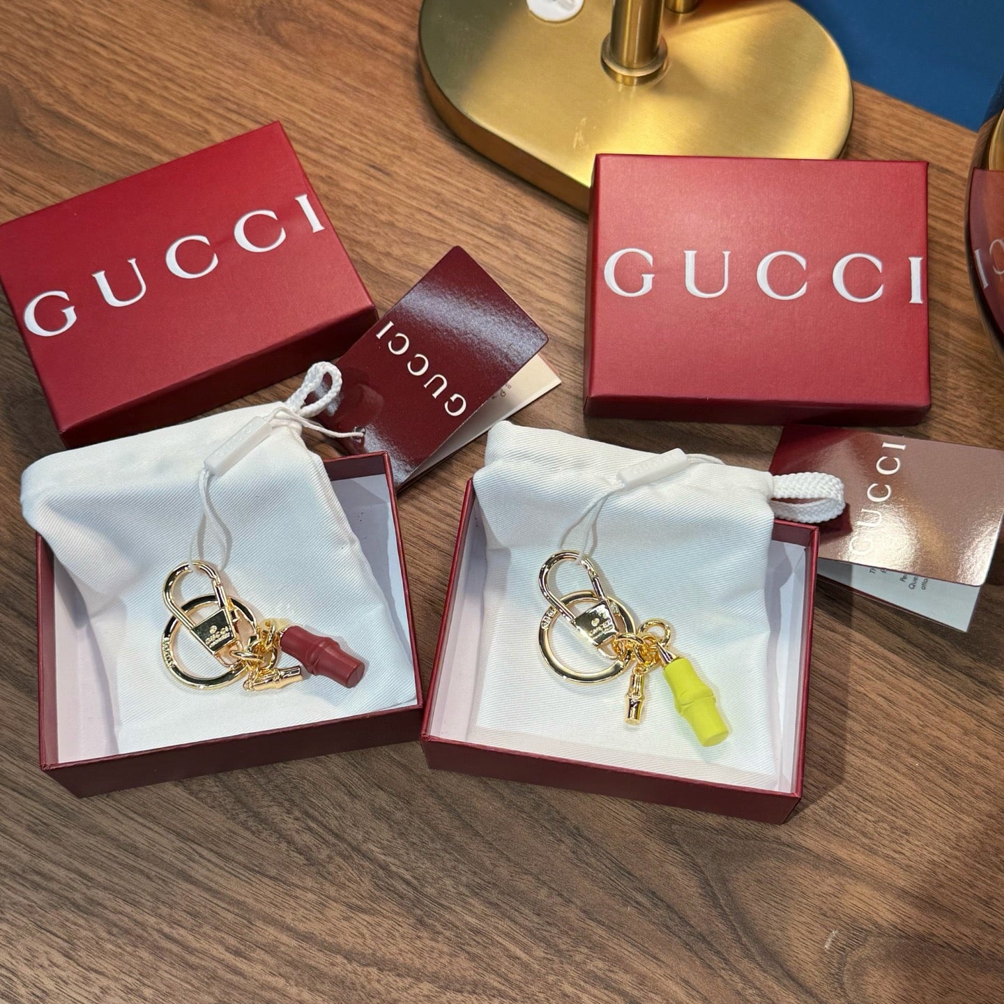 Gucci keychain pair with gold rings and red/green tassels in gift boxes