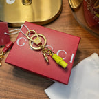 Gucci keychain: gold keyring with lock charm and lime green tag, in red gift box