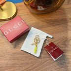 Gucci keychain with gold hardware and lime green charm, with dust bag and cards