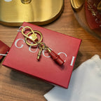 Gucci keychain with gold lock and red leather tassel on red box