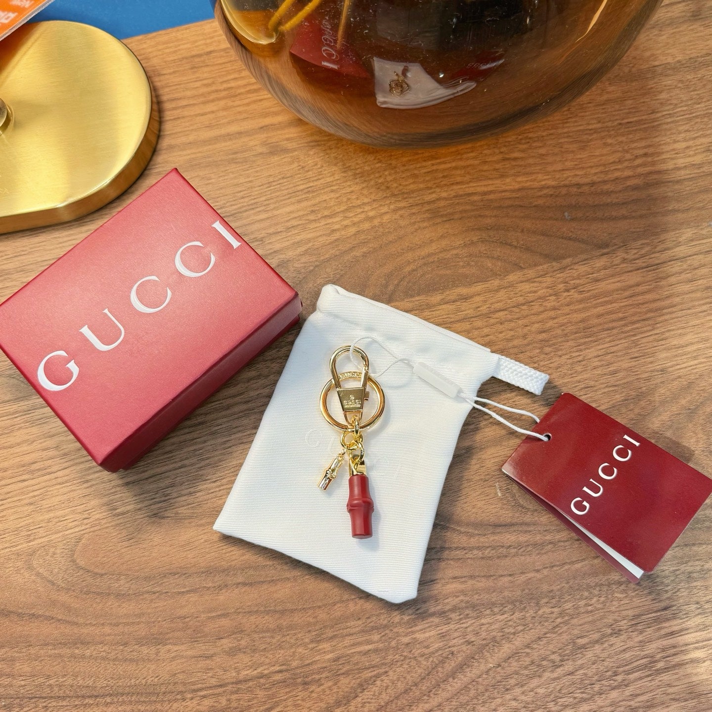 Gucci keychain with gold rings and red tassel, with dust bag and box