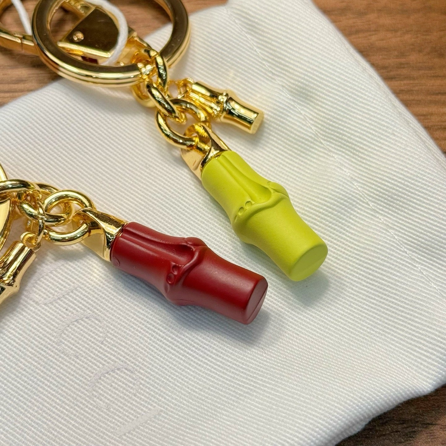 Gold-tone keychain set with lime and red barrel charms and circular key rings