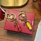Gold-tone keychain pair with lime and red capsule charms and circular key rings