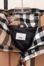 Plaid puffer vest inside view with hanging tag and black trim near the neckline