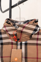 Burberry plaid hooded puffer jacket on a hanger with orange hanging tag