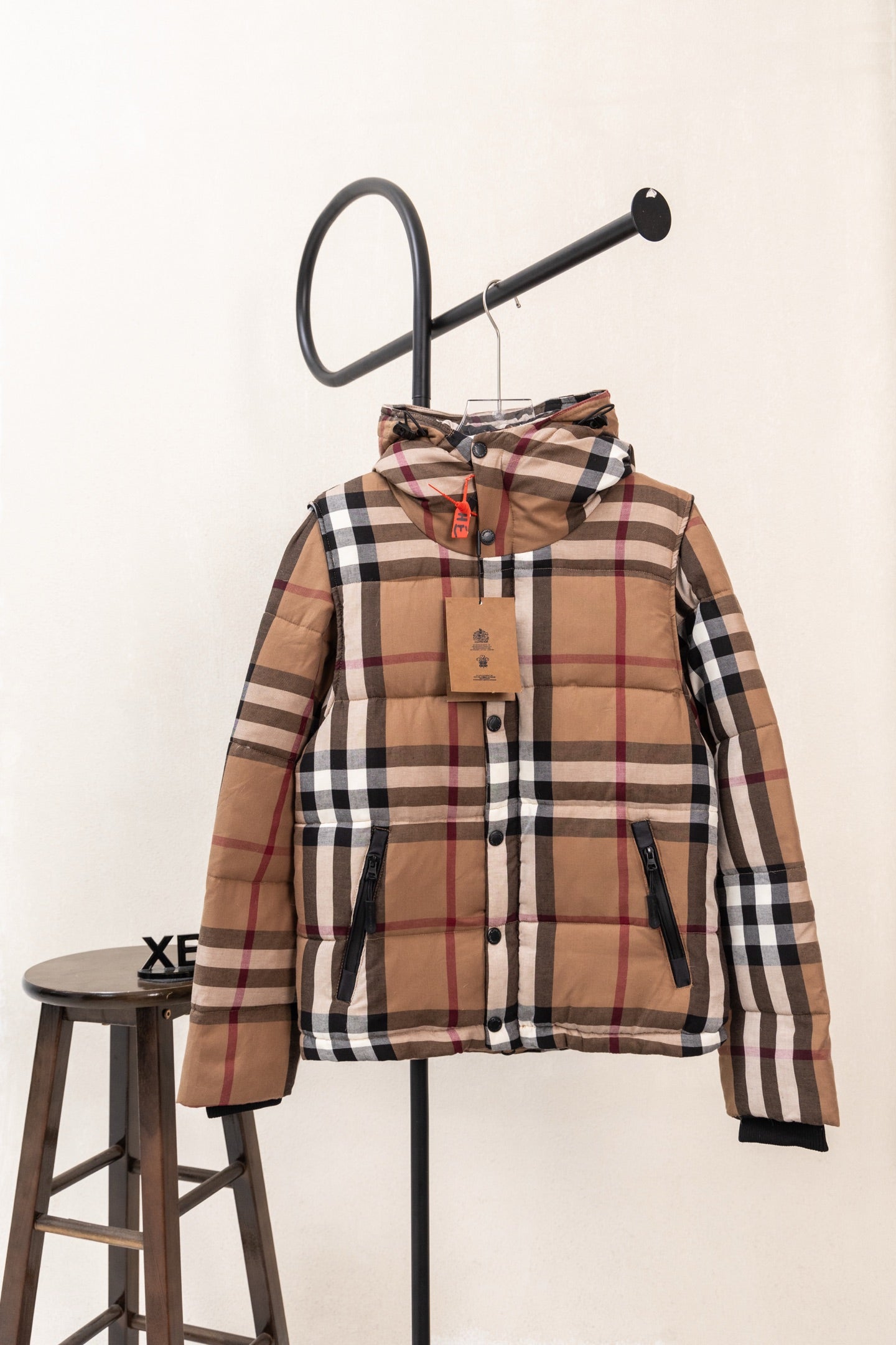 Hooded plaid puffer vest with front zipper and brown, black, white, and red checks