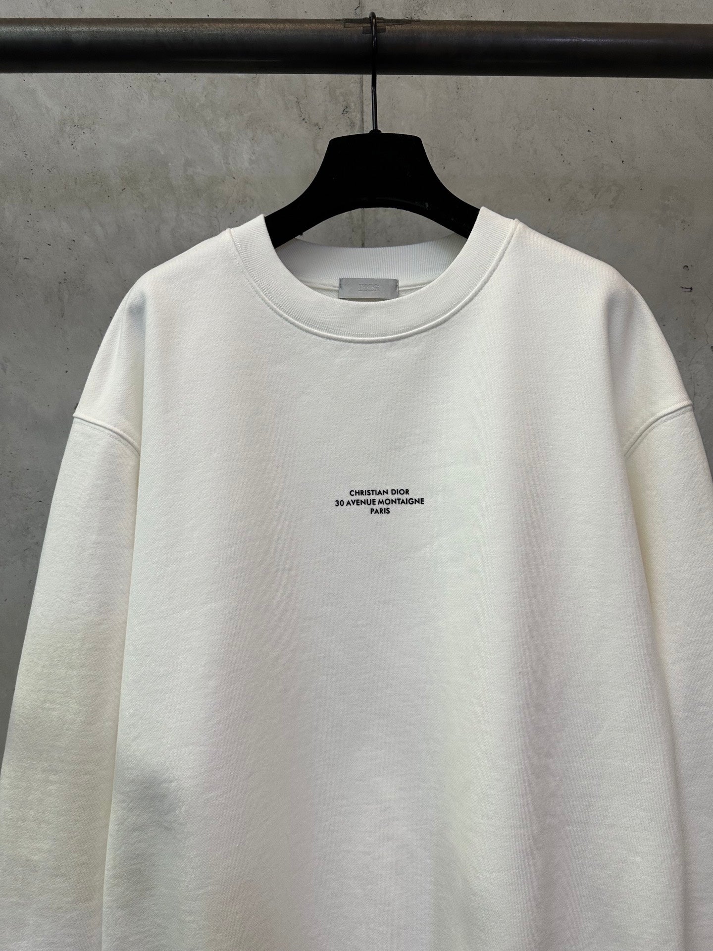 White crewneck sweatshirt with small logo text at the chest