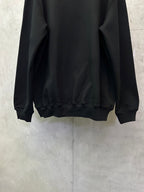 Black crewneck sweatshirt lower back view with ribbed hem
