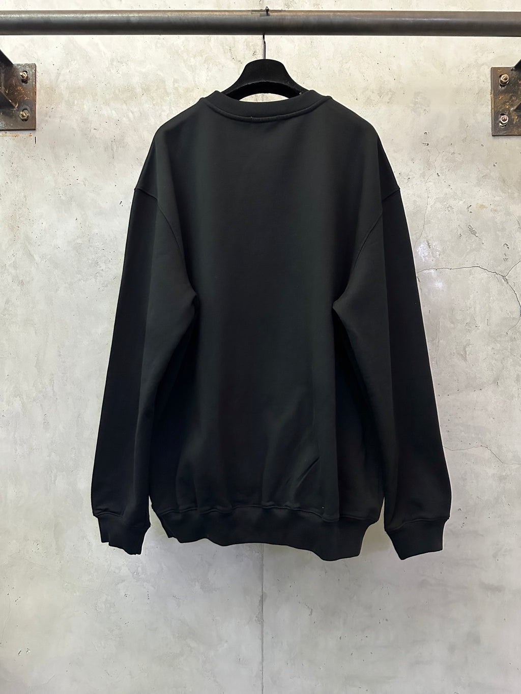 Black crewneck sweatshirt back view with ribbed cuffs