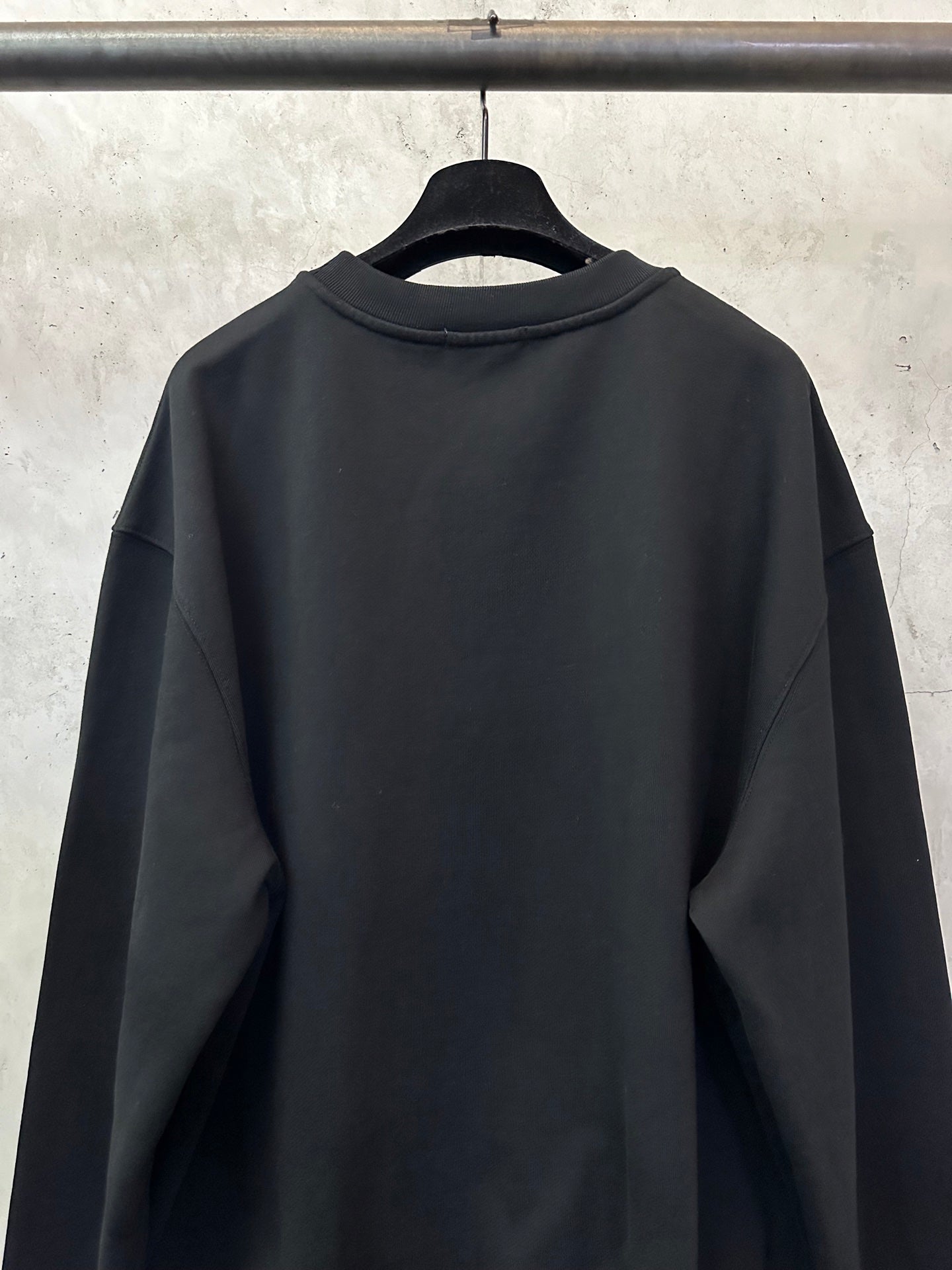 Black crewneck sweatshirt back view with rounded collar