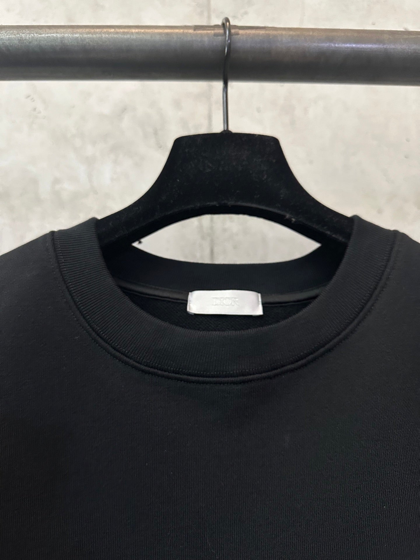 Black crewneck sweatshirt neckline with inner size label