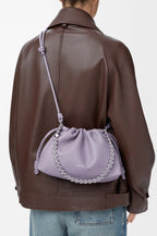 Lavender drawstring pouch bag with silver chain shoulder strap on model back