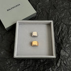 Balenciaga logo accessory with gold-toned rectangular emblem in gift box