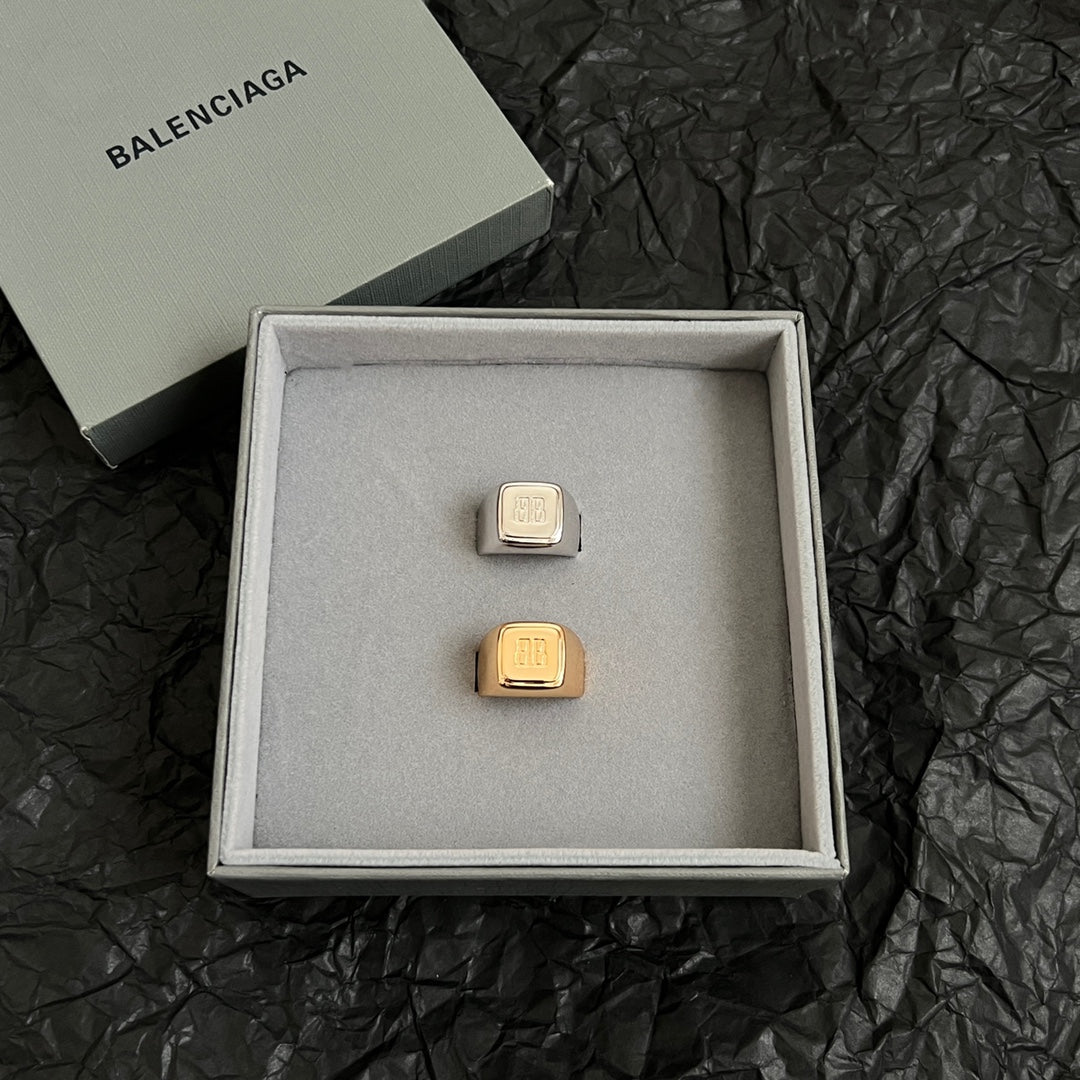 Balenciaga logo accessory with gold-toned rectangular emblem in gift box