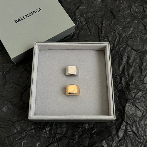 Balenciaga logo accessory with gold-toned rectangular emblem in gift box