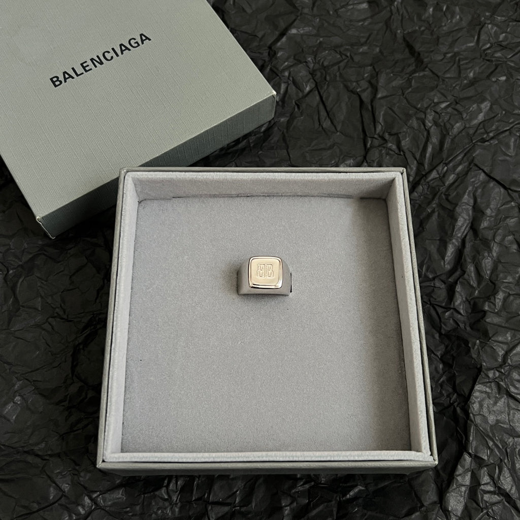 Balenciaga logo accessory with gold-toned rectangular emblem in gift box