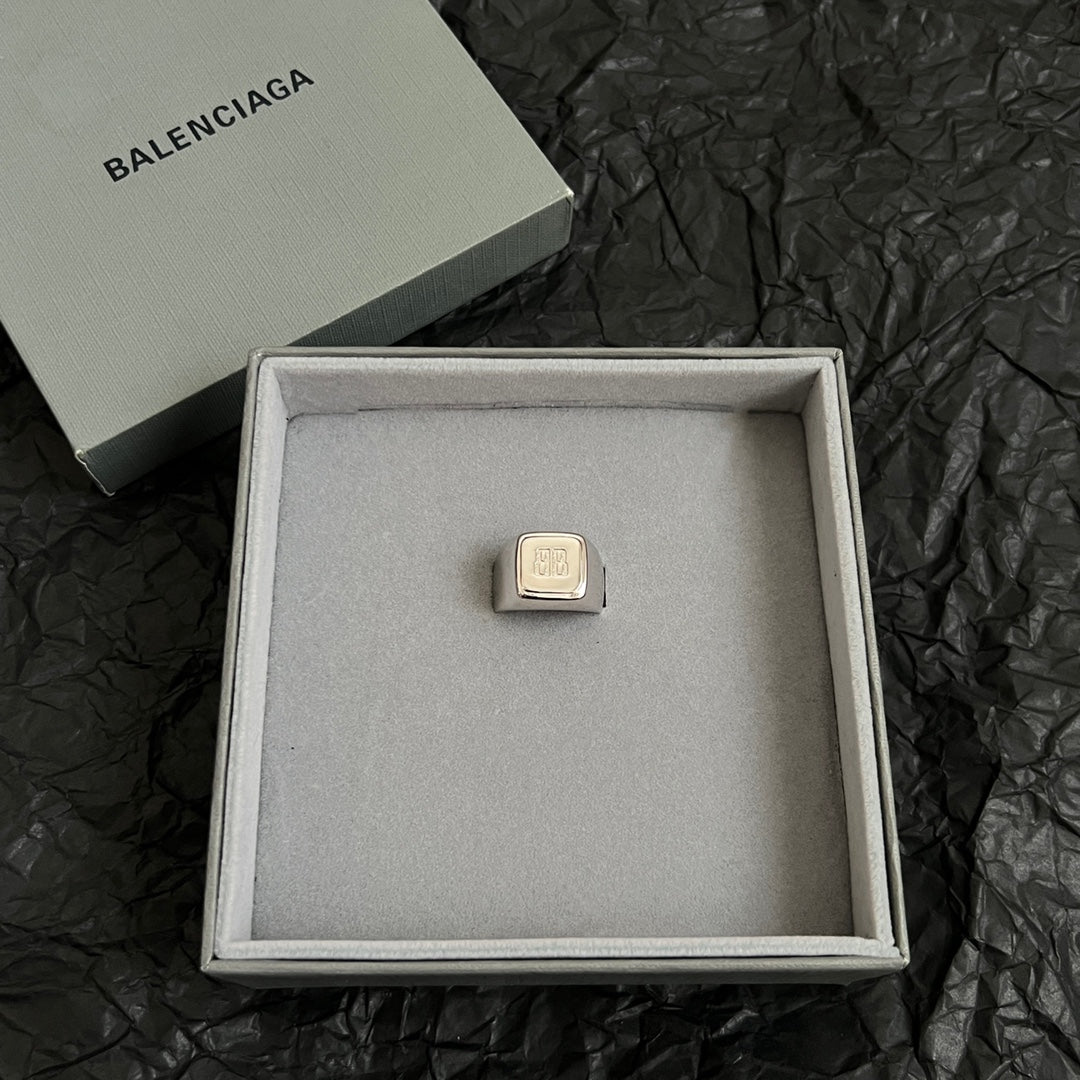 Balenciaga logo accessory with gold-toned rectangular emblem in gift box